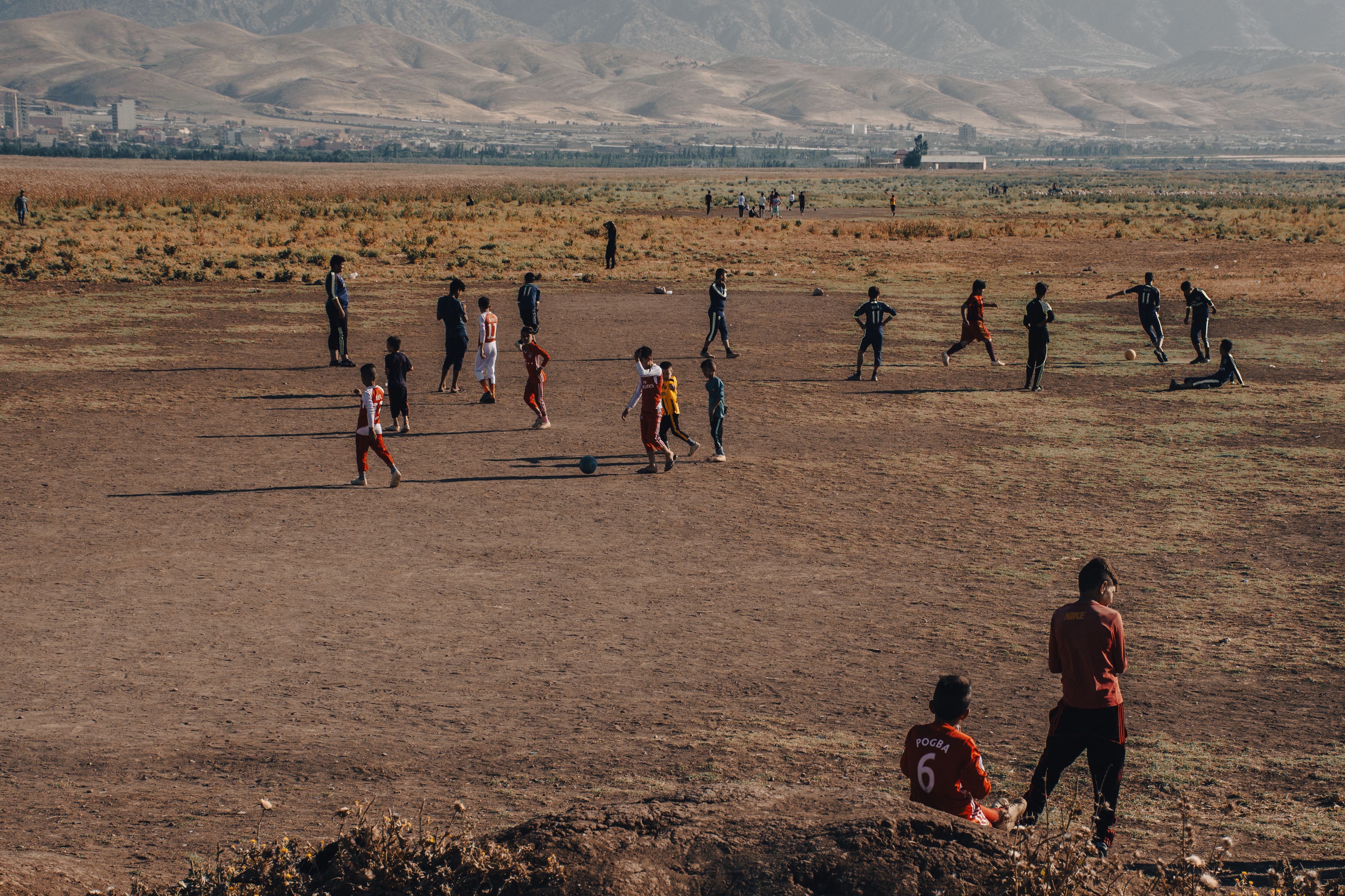Rural Soccer Game in Open Field with Mountain View · Free Stock Photo