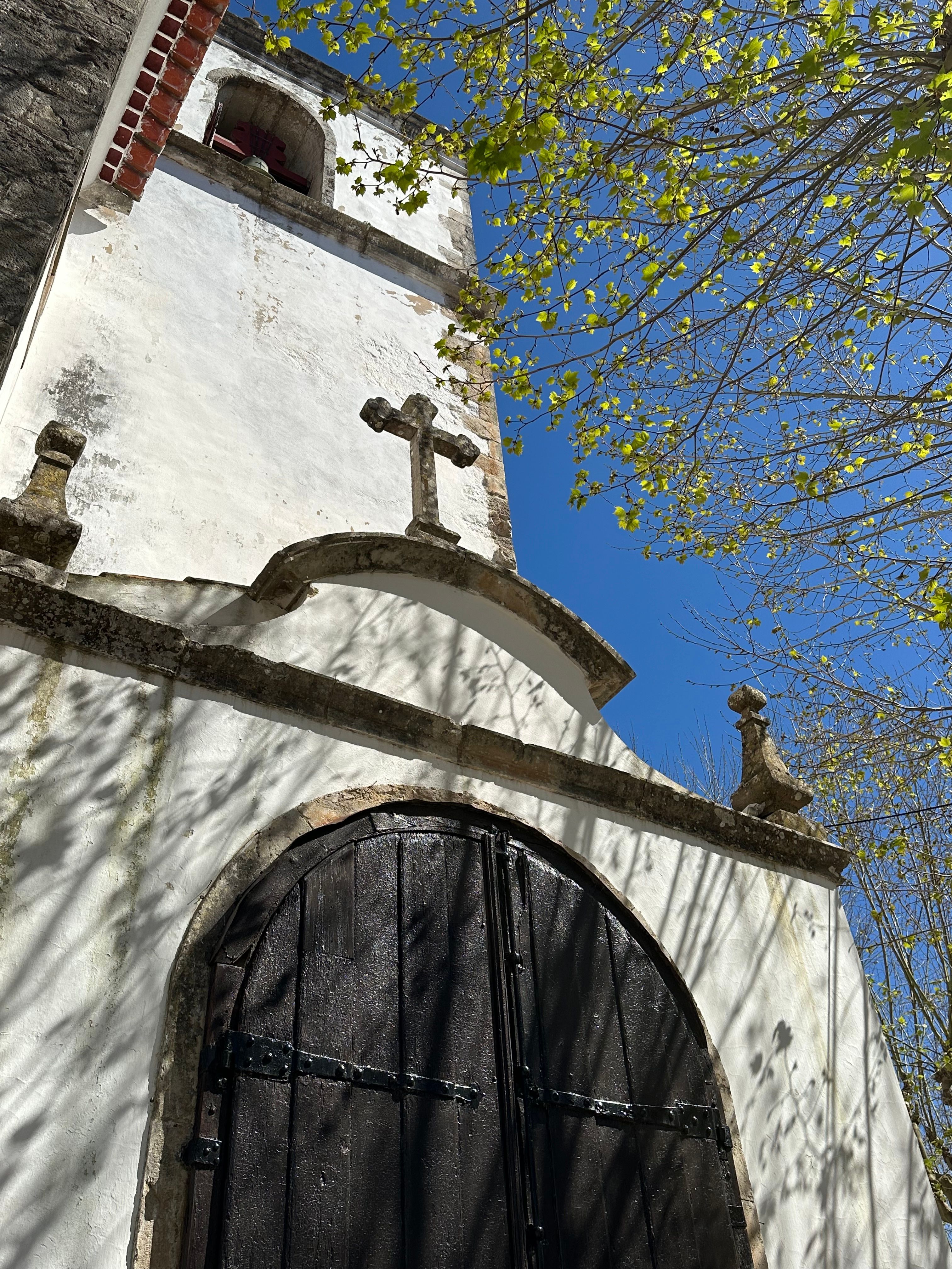 Fotomural Una capilla histórica en Óbidos, Portugal, con una arquitectura clásica bajo un cielo azul claro.
