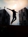 在戏剧性的天空映衬下，人在建筑物之间跳跃