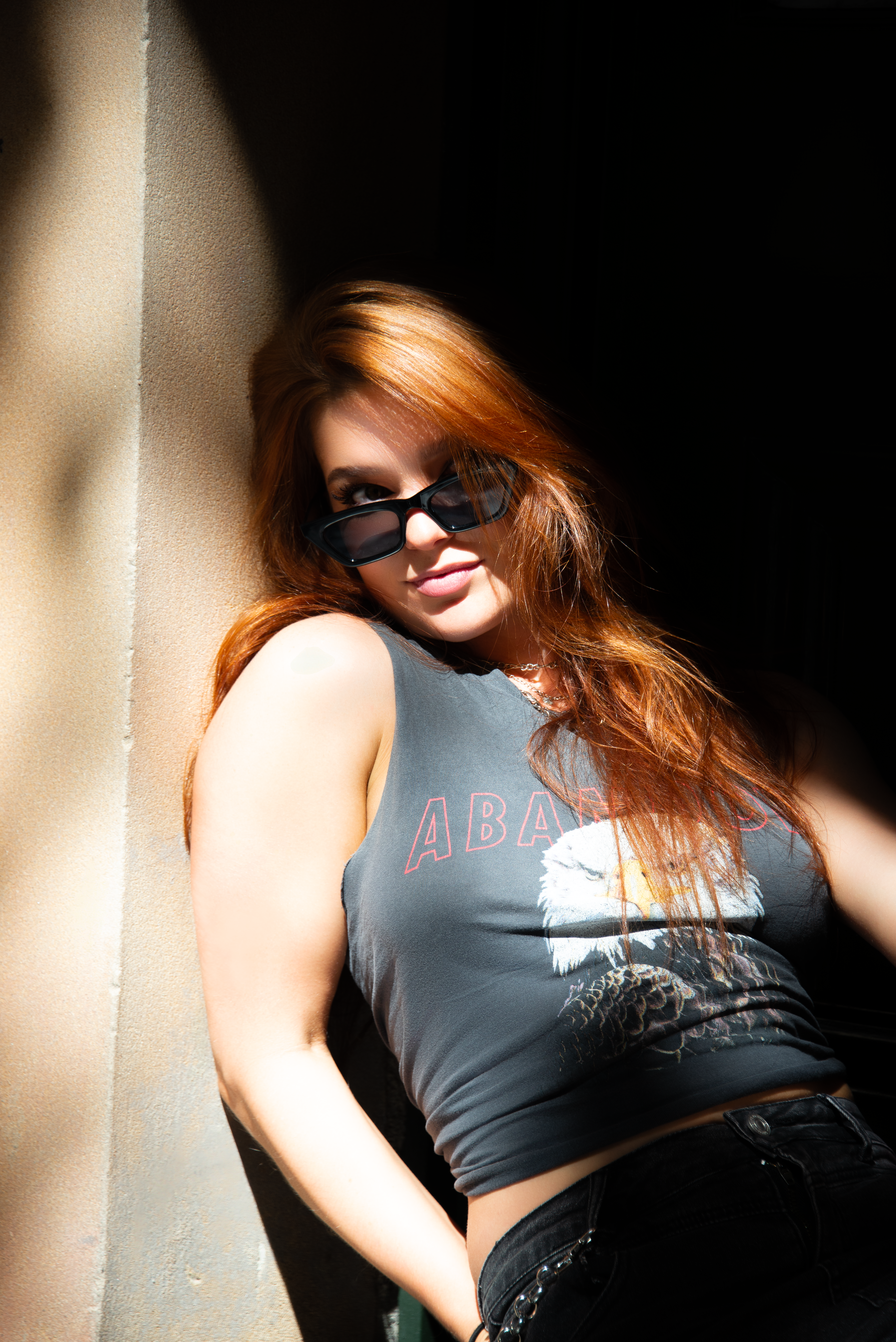 Chic woman with sunglasses posing in sunlight in Sydney, Australia