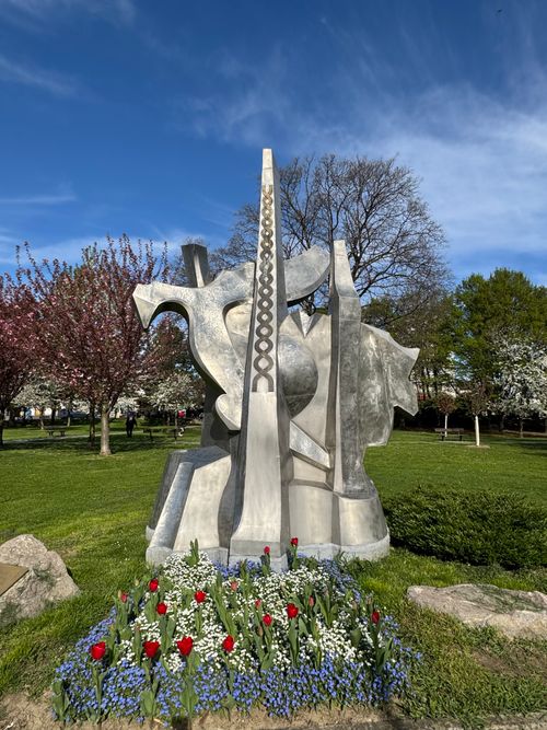 Free A striking abstract sculpture surrounded by vibrant spring blooms in a Zagreb park. Stock Photo