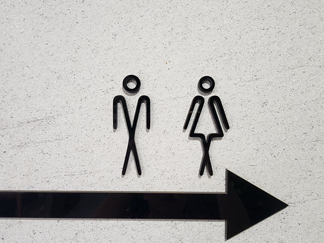 Minimal pictogram signage on a concrete wall — photo by Kidong Kim on Pexels