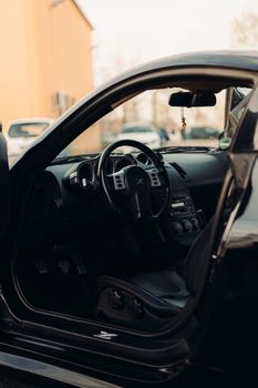 Detailed view of a black car's luxurious interior with the door ajar.