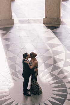 一对穿着正式的夫妇，在图案精美的中庭里相拥，画面浪漫而精致