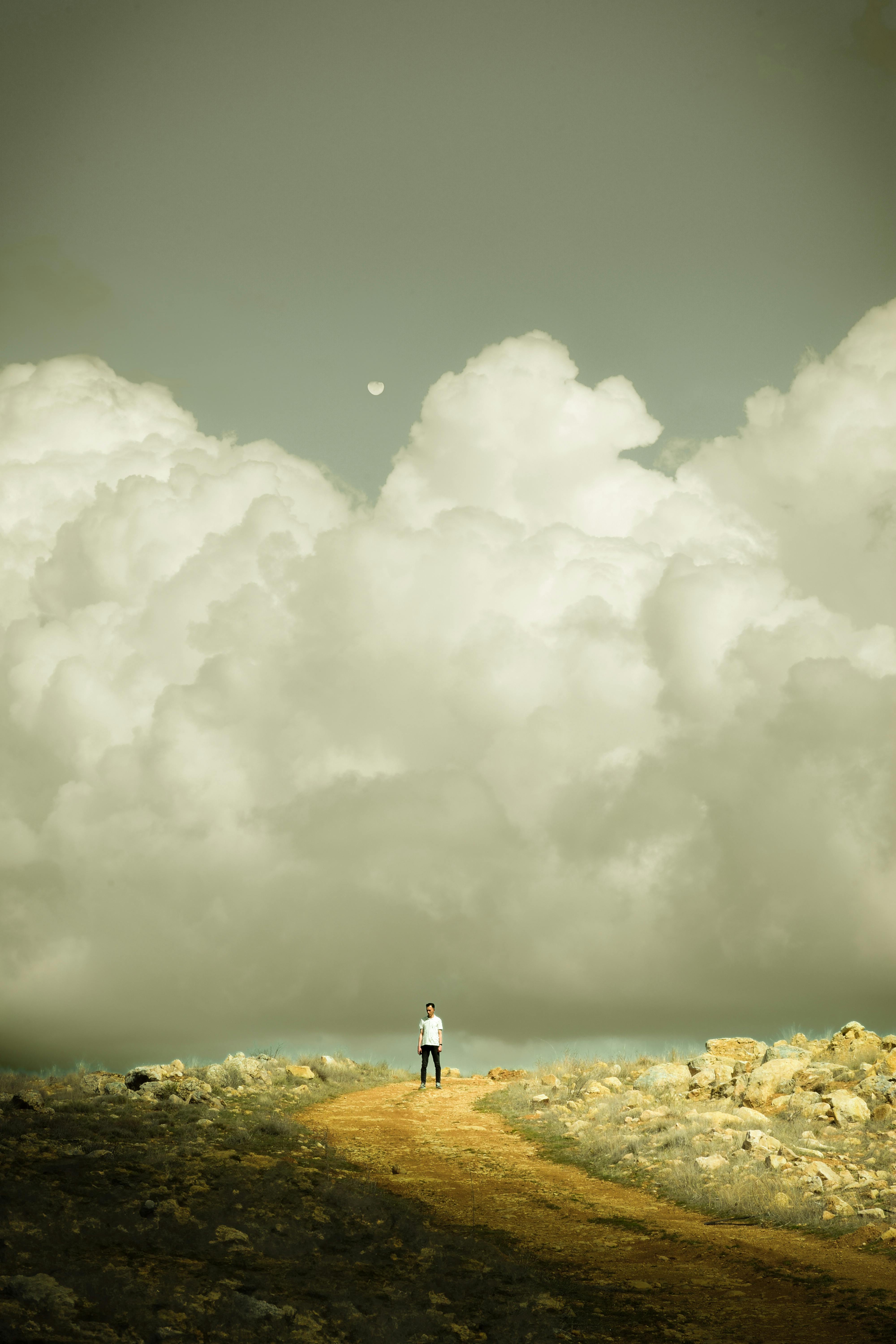 A solitary person stands beneath looming, dramatic clouds in Darende, Turkey.