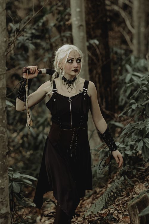 Free Gothic woman holding a sword in a mysterious forest setting. Stock Photo