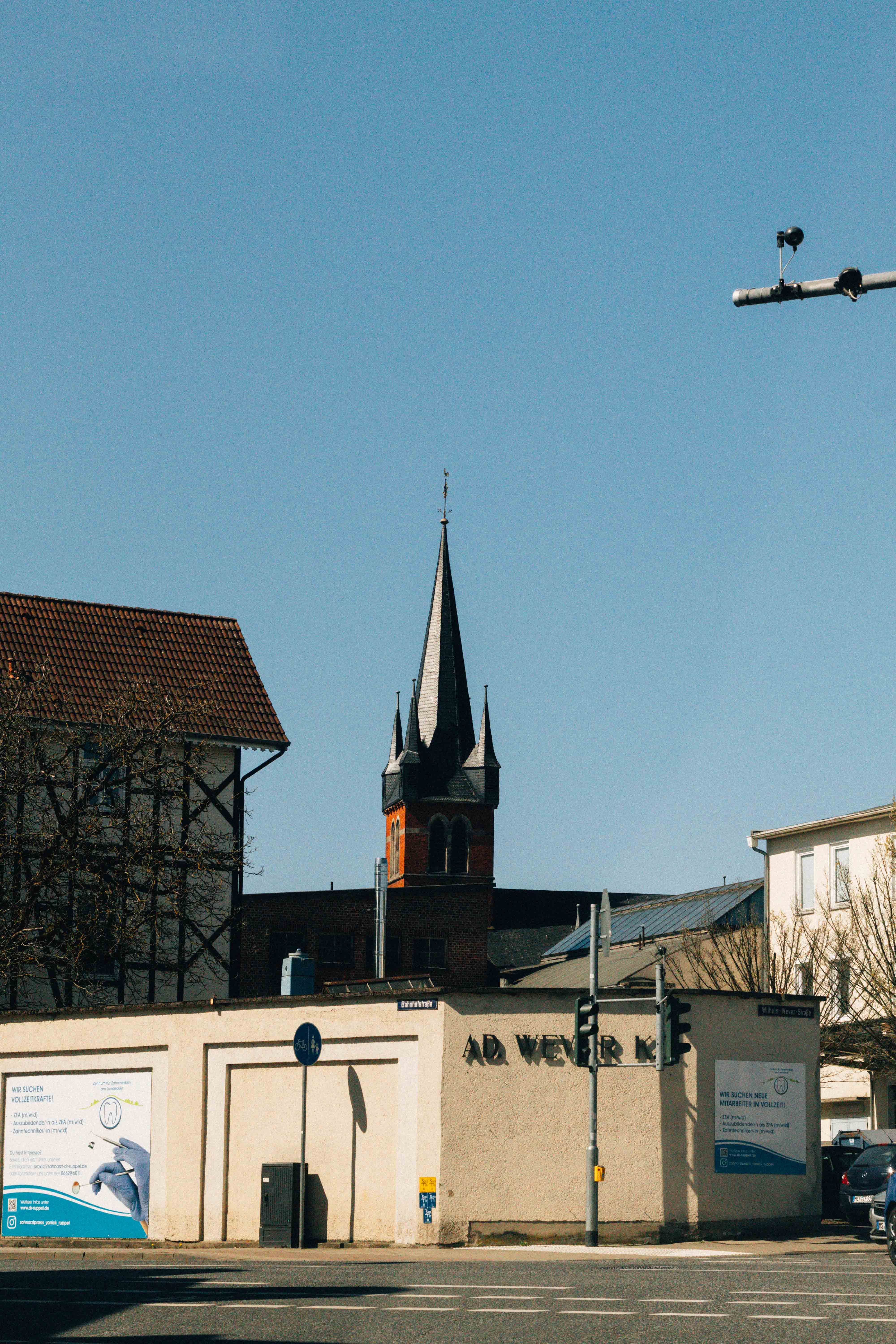 Urban landscape featuring historic buildings, a tower, and clear blue sky.