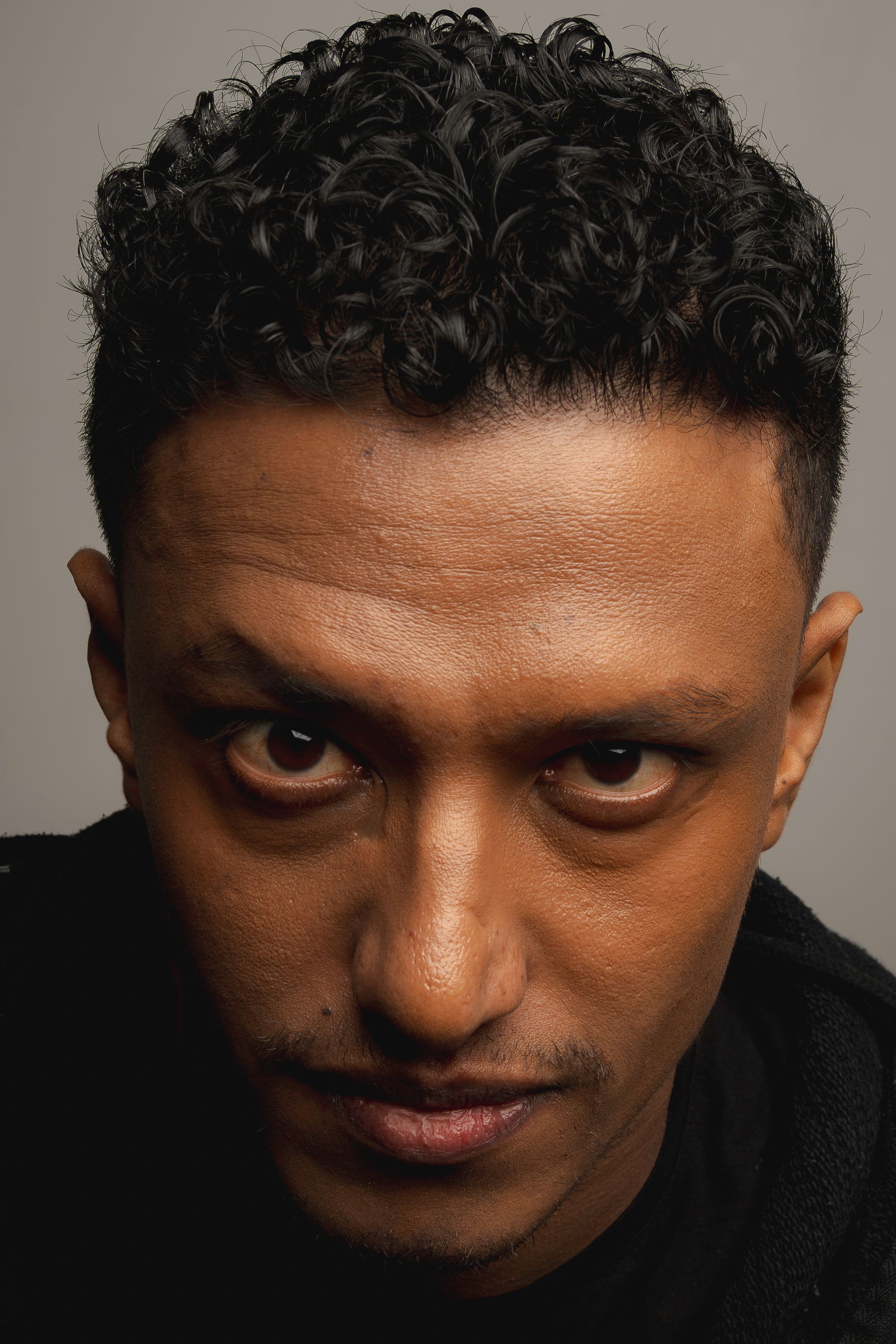 A powerful close-up portrait of a male model with an intense stare taken in a Berlin studio session.
