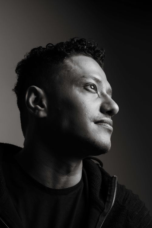 Free Elegant black and white portrait of a man looking away with a contemplative expression in a studio setting. Stock Photo