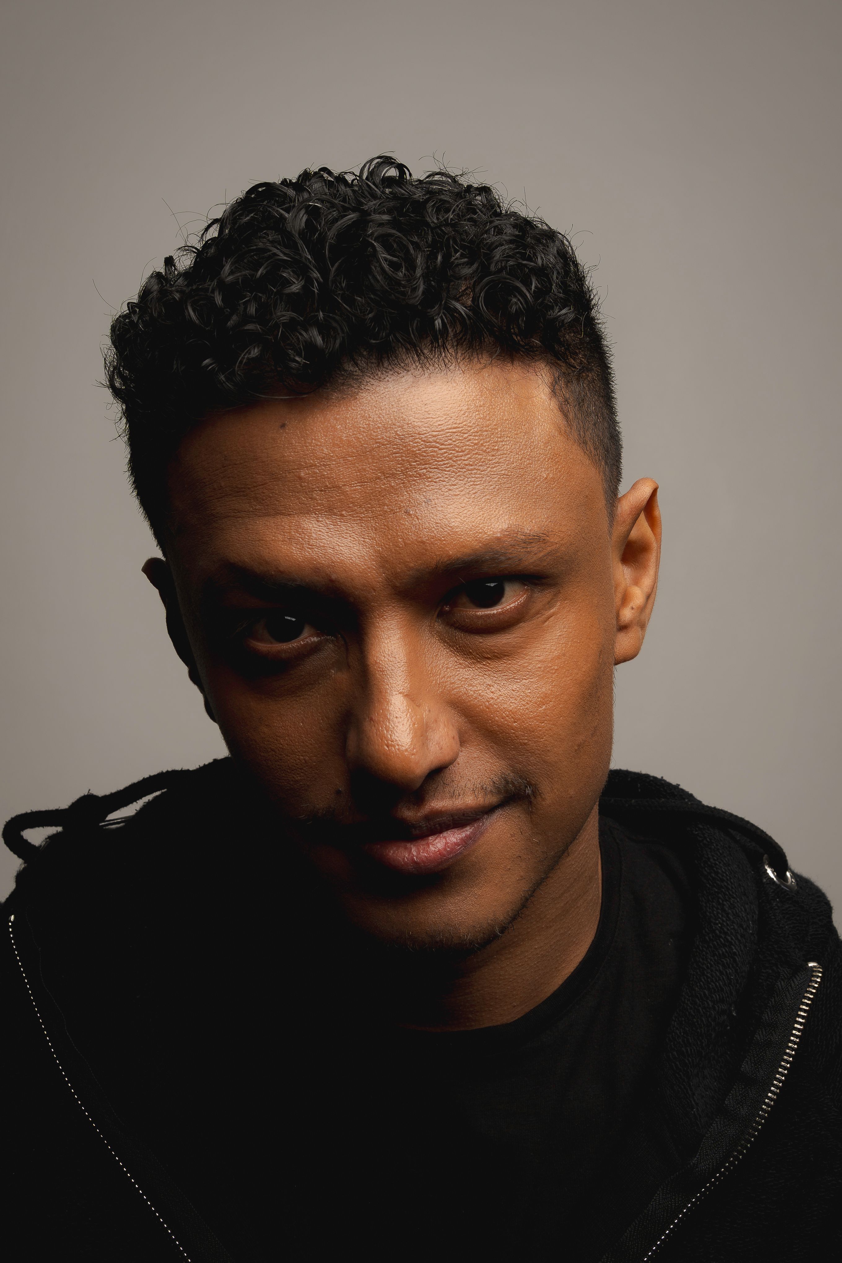 Intense portrait of a male model with an engaging stare, captured in a Berlin studio.