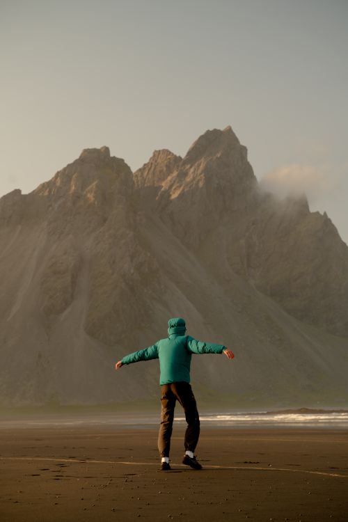 Adventurous Pose in Front of Icelandic Mountain · Free Stock Photo