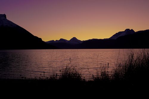 Free Breathtaking sunset view over a calm lake in Norway with silhouetted mountains. Stock Photo