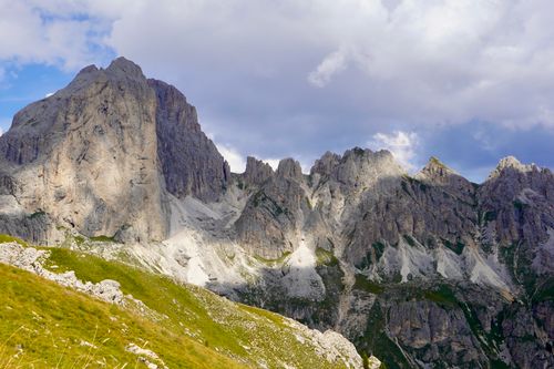 Free Breathtaking view of the Dolomites mountain range with dramatic peaks and clouds casting shadows. Stock Photo