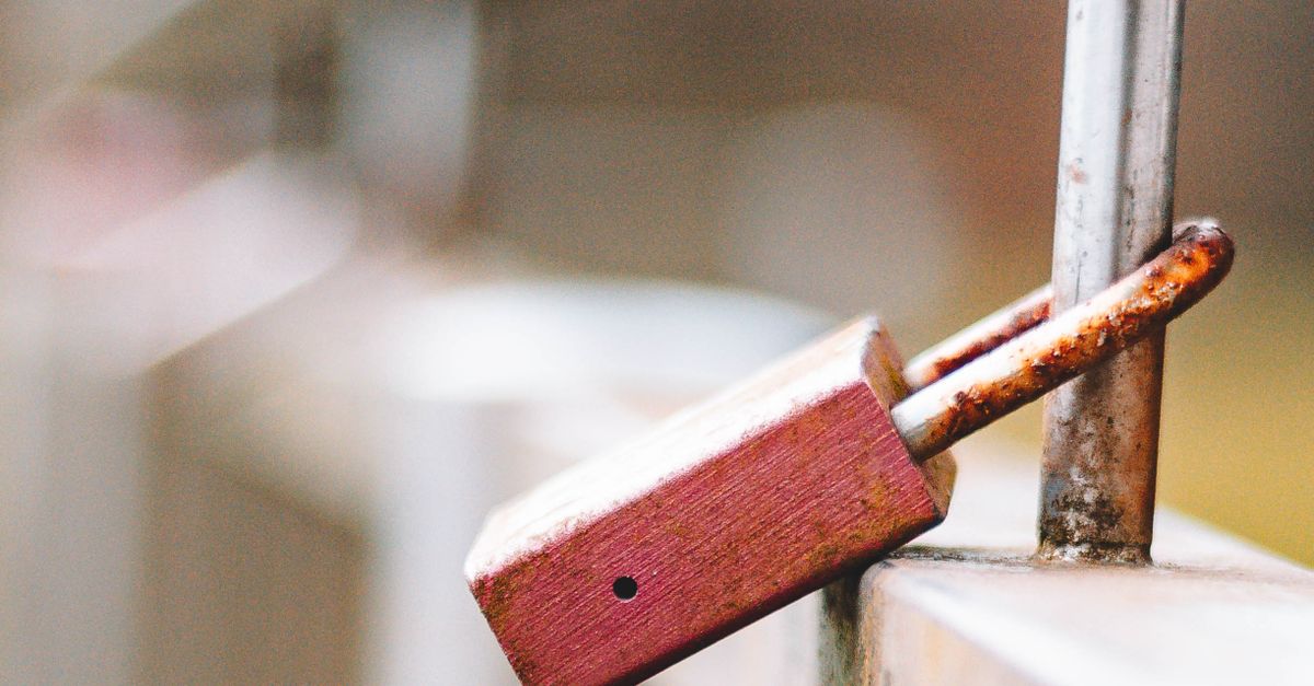 Rusty Padlock on Weathered Metal Railing · Free Stock Photo