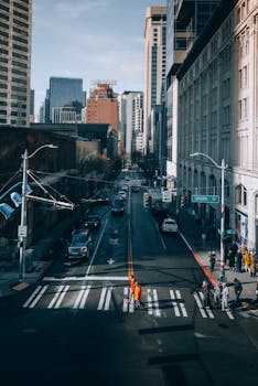 A dynamic street view of Seattle with pedestrians and vehicles on a busy city road during the day.
