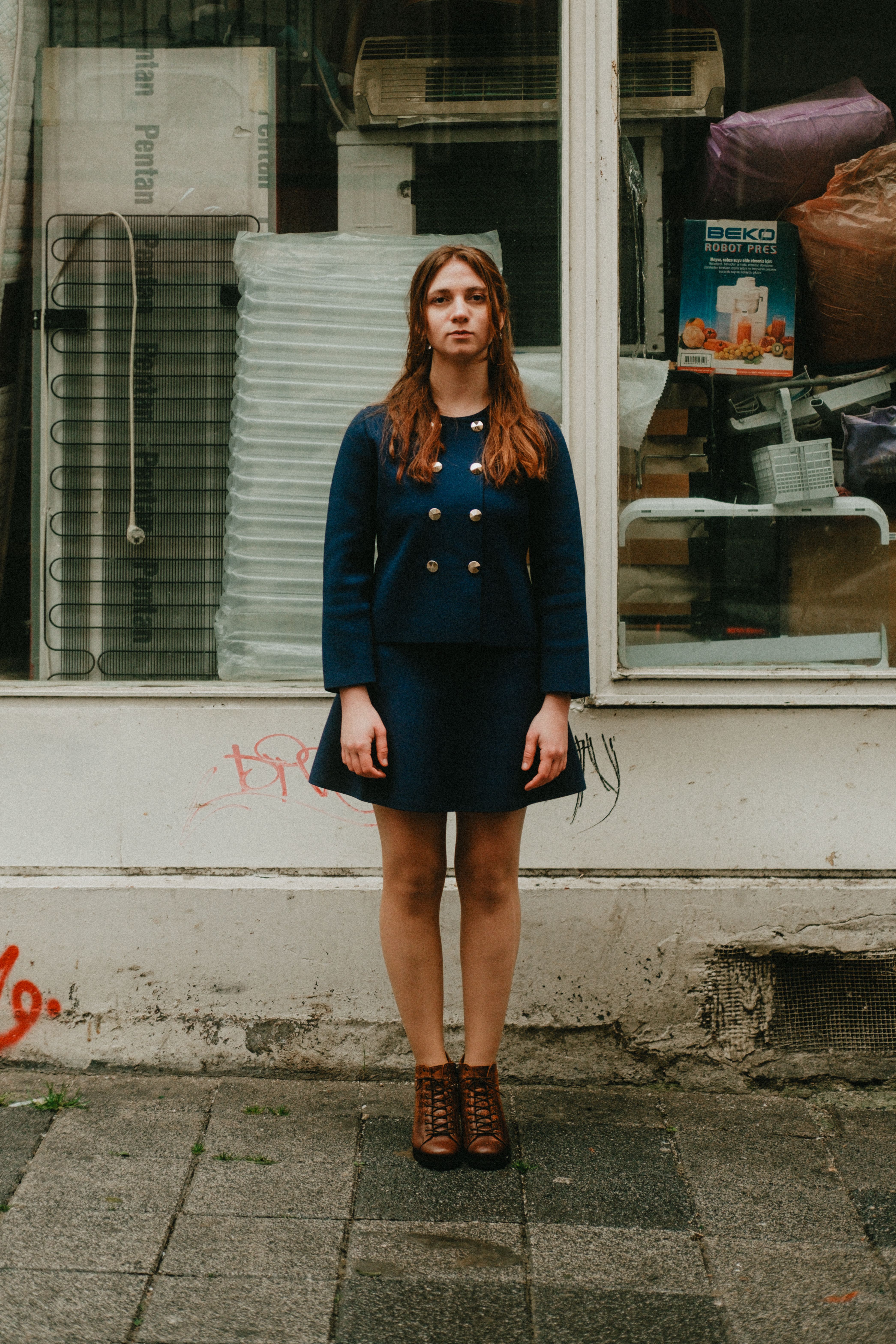 Portrait of a woman standing in front of a shop window in Istanbul, Türkiye.