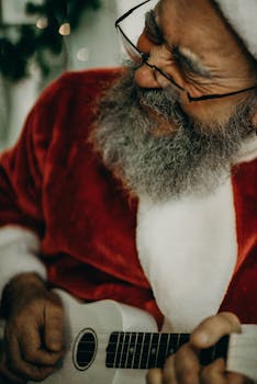 穿着圣诞老人服装的老人弹着吉他，洋溢着节日的欢乐