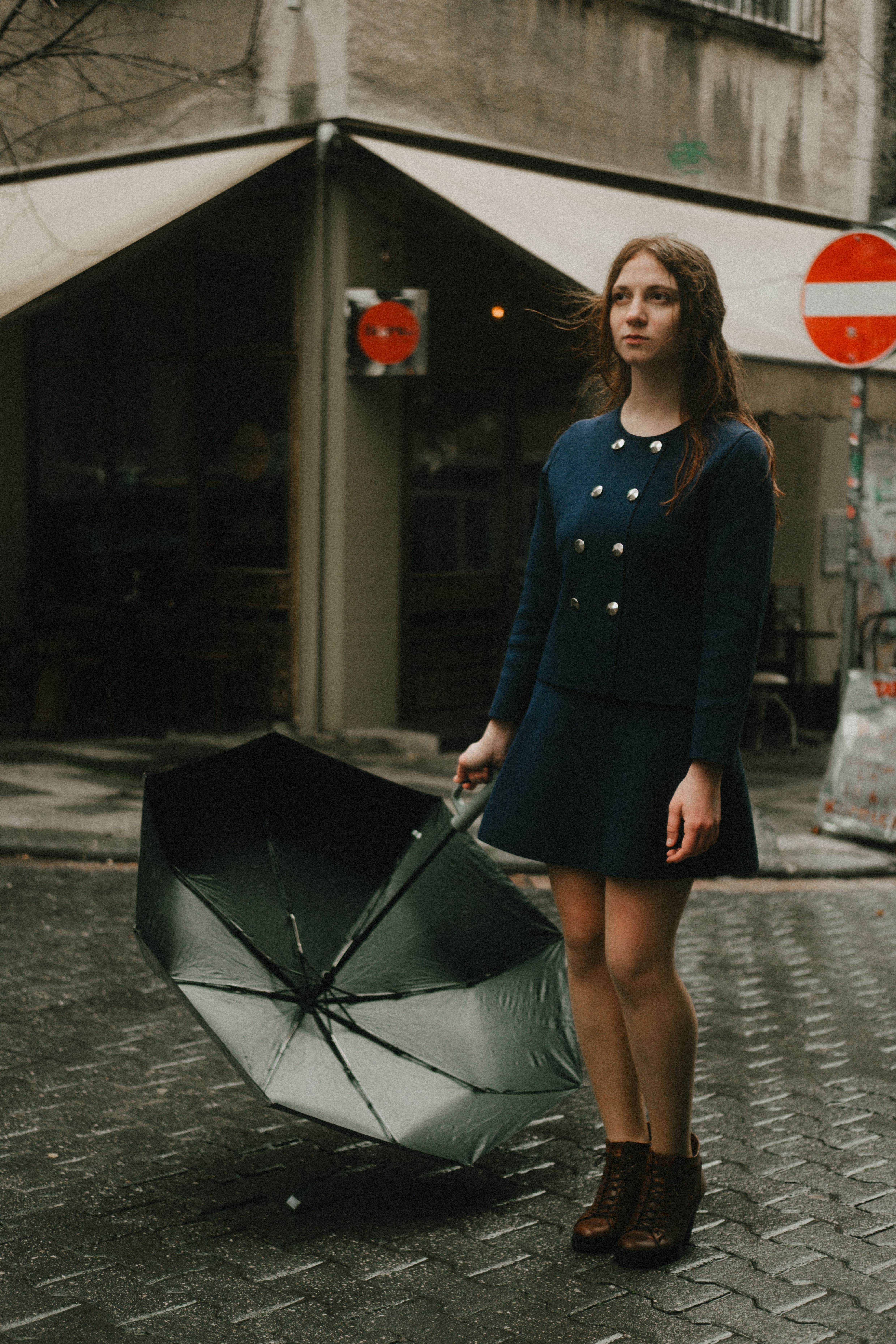 Young Woman Holding Umbrella on Rainy Street · Free Stock Photo