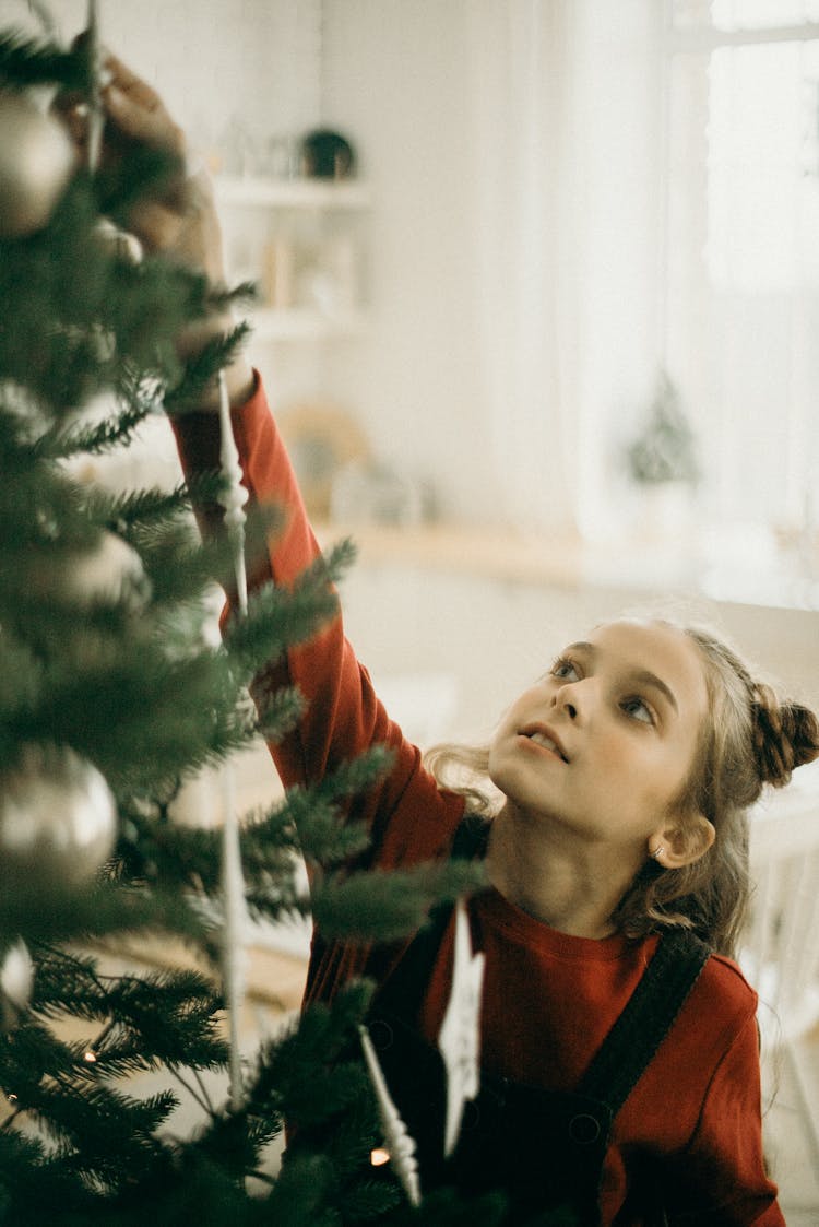 Girl Reaching The Top Of A Christmas Tree