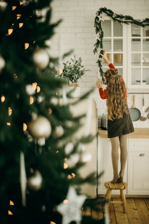 Girl Putting A Christmas Decoration