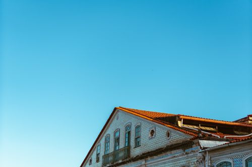 Free A historic building with a tiled roof against a bright, clear blue sky. Stock Photo