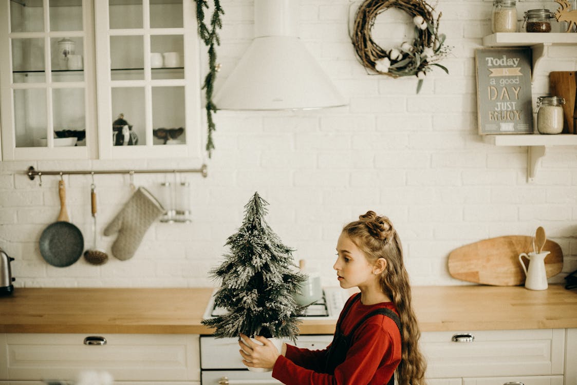 Menina Segurando Uma Pequena Decoração De árvore De Natal