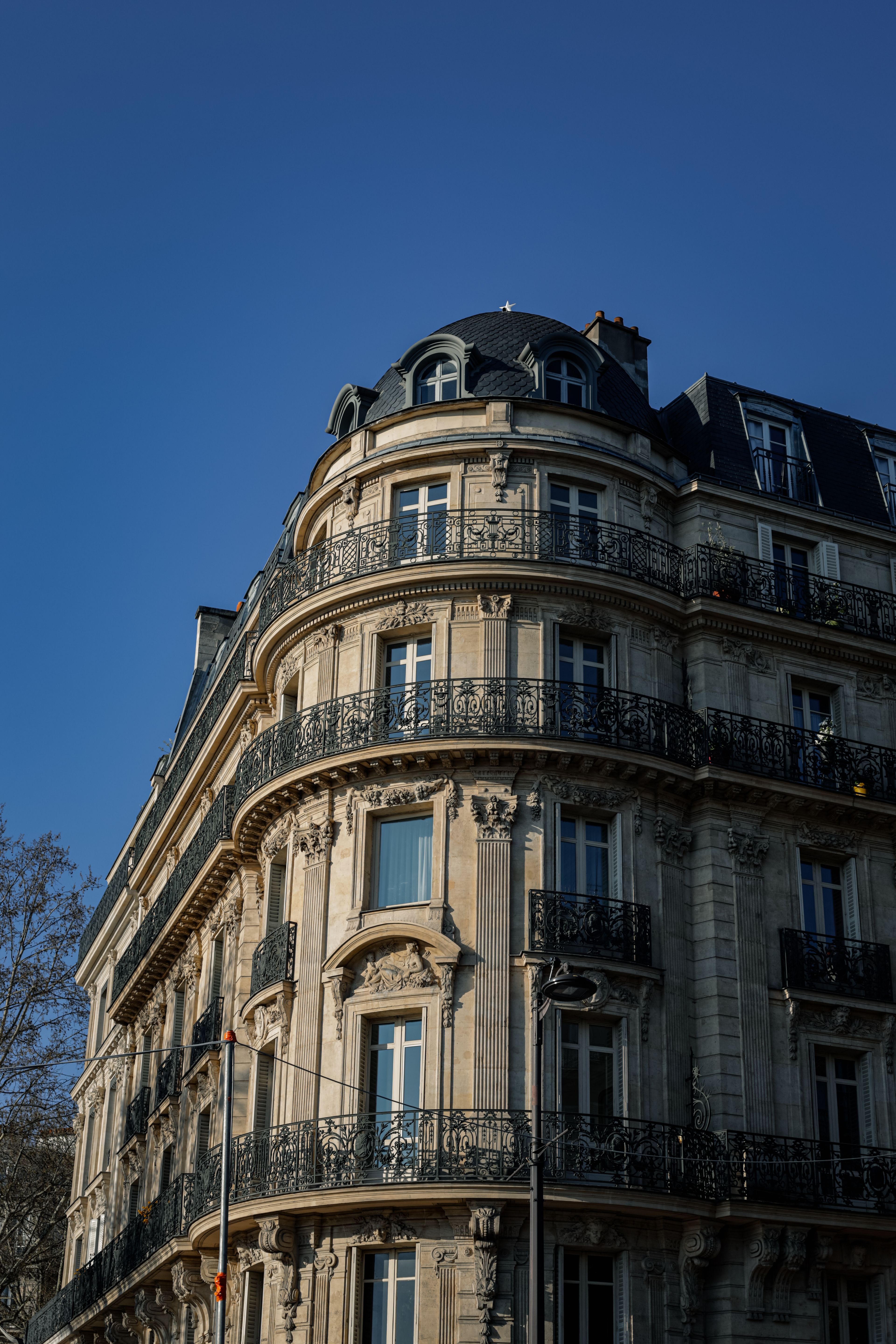 Immeuble parisien du dix-neuvième siècle aux balcons finement ouvragés.