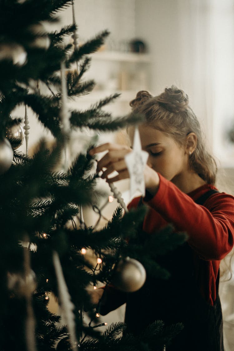 Person Decorating A Christmas Tree