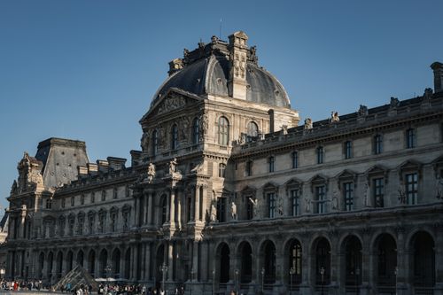 Free Elegant 19th-century architecture of the Louvre Museum in Paris, showcasing timeless beauty and grandeur. Stock Photo