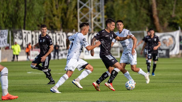 Players in action during a competitive soccer match on a lush, green field.