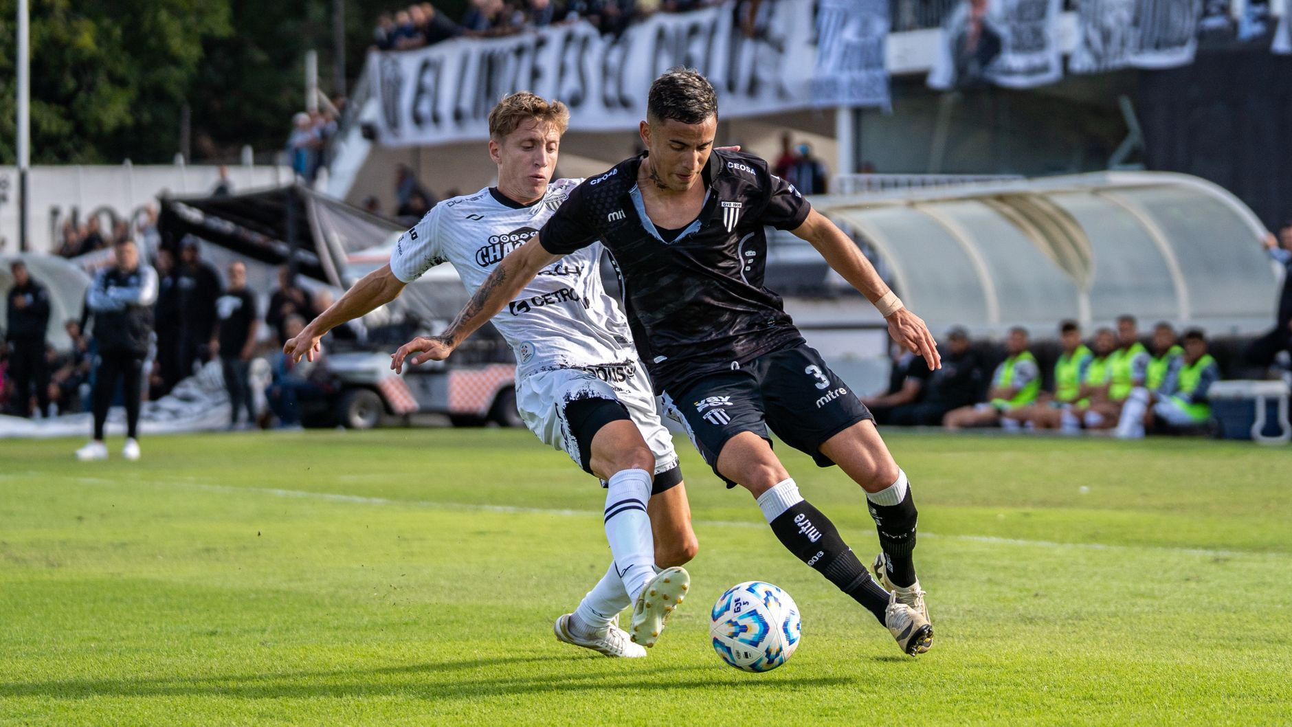 Two soccer players in action during a competitive outdoor match.