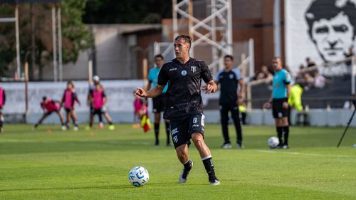 Free A soccer player in black uniform dribbles the ball during an outdoor match. Stock Photo