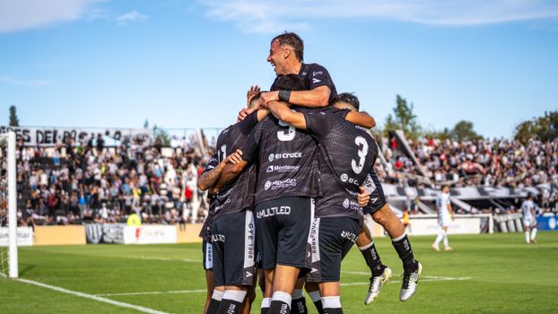Exciting soccer match moment with team celebrating a goal on the field.