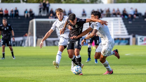 Soccer players in an intense competition on a sunny day during a match.