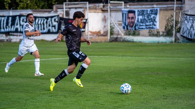 Two soccer players in action on a vibrant green field during a daytime match.