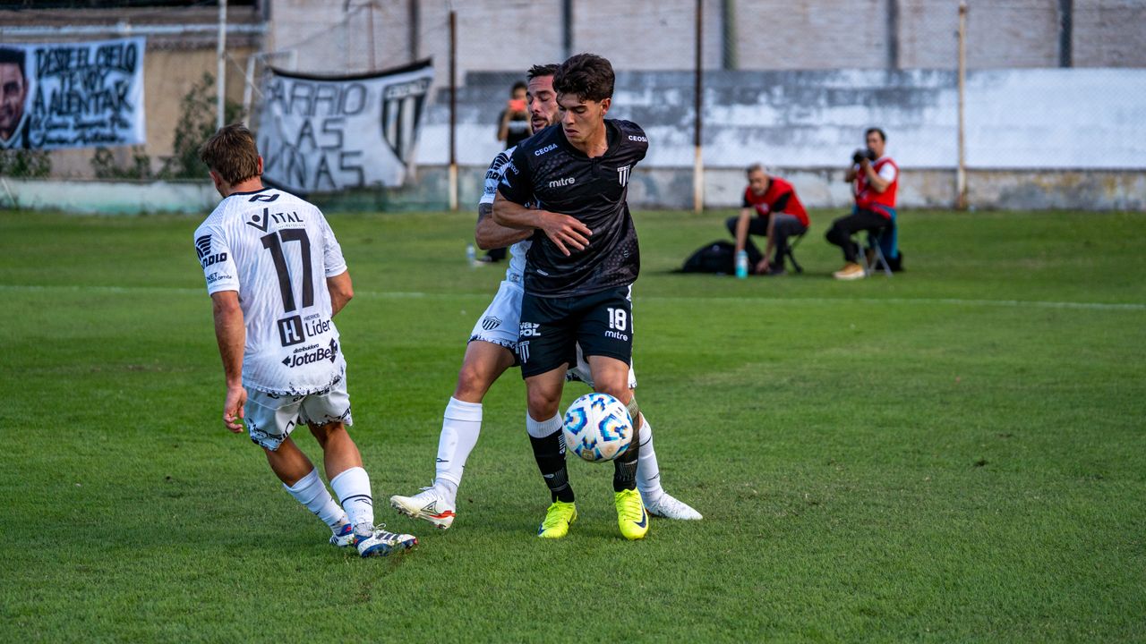 two soccer players competing intensely on a green field during a dayti