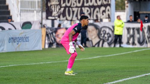 Free Soccer goalkeeper in vibrant pink uniform poised during a match on a bright day. Stock Photo