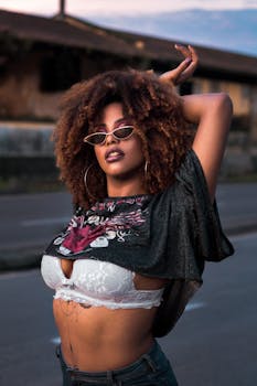 一位卷发自信的女人戴着时尚太阳镜，在街头户外摆出时尚姿势