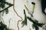 白色木制背景上平躺的创意圣诞装饰冷杉树枝