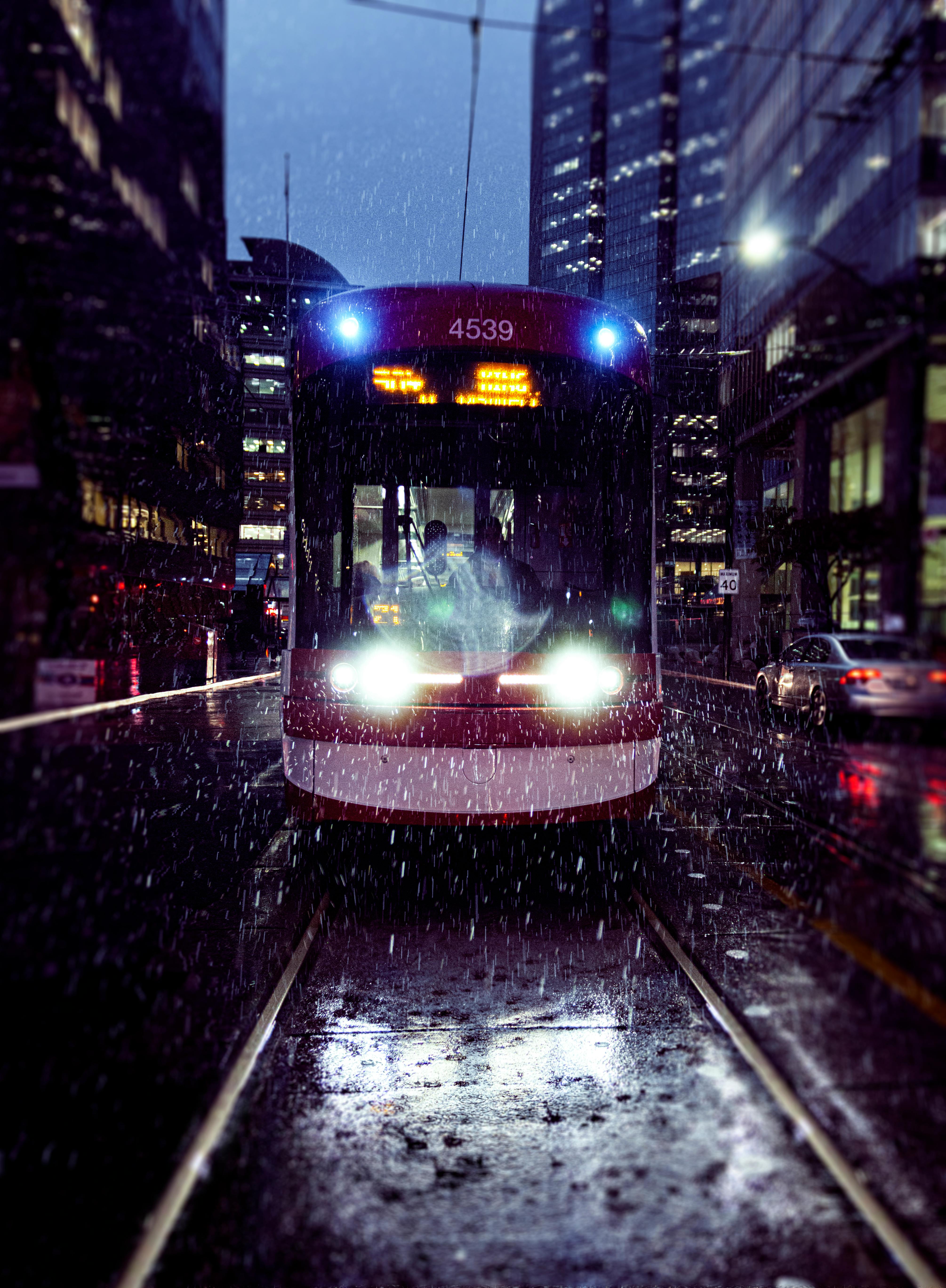red and white tram on a rainy night