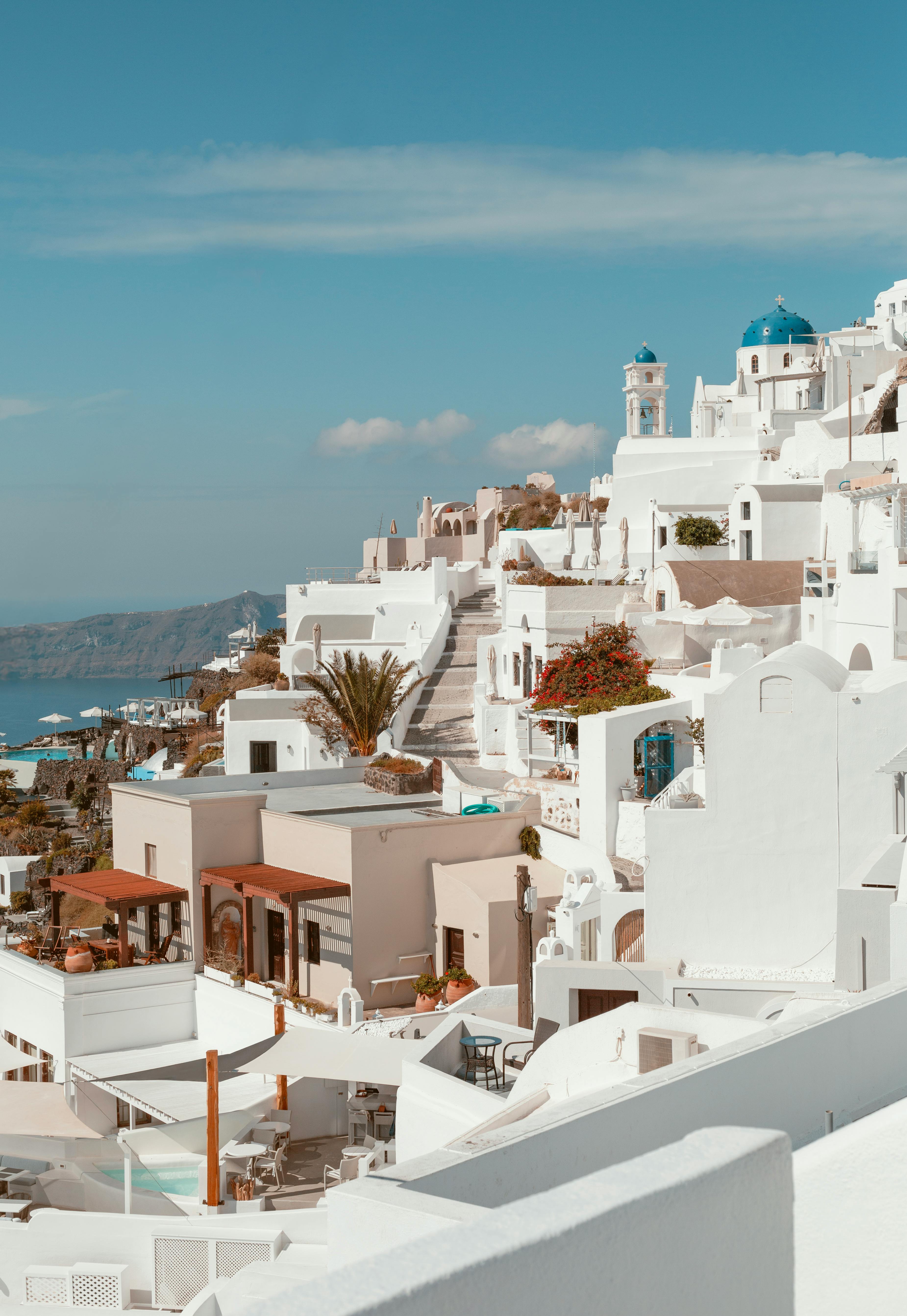 Breathtaking view of Fira in Santorini, showcasing iconic white structures and blue domes under a clear blue sky.