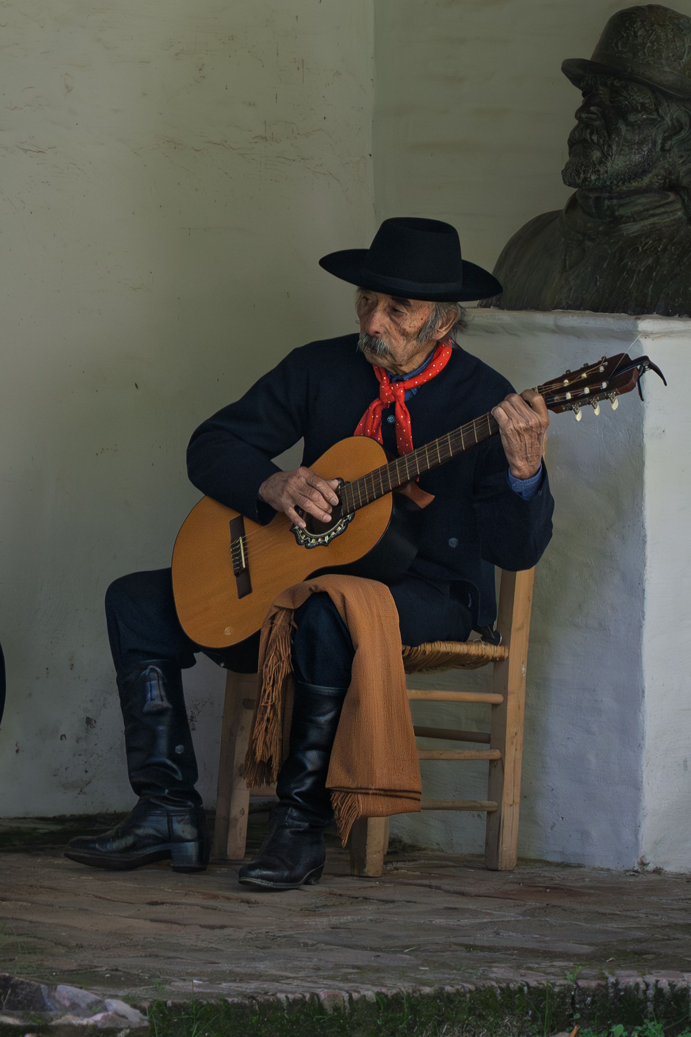 An Argentine gaucho playing guitar outdoors in San Antonio de Areco, Buenos Aires.