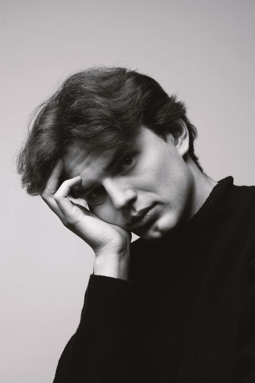 Free Black and white portrait of a young man in deep thought, hand on face. Stock Photo