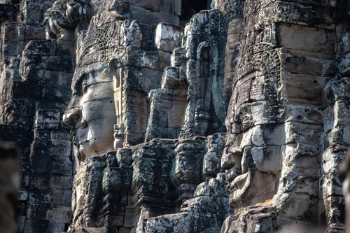 Free Intricate stone carvings of faces at Bayon Temple in Angkor Thom, Cambodia, captured in natural light. Stock Photo