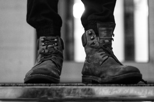 Free Tough leather boots worn outdoors, highlighting rugged style in monochrome. Stock Photo