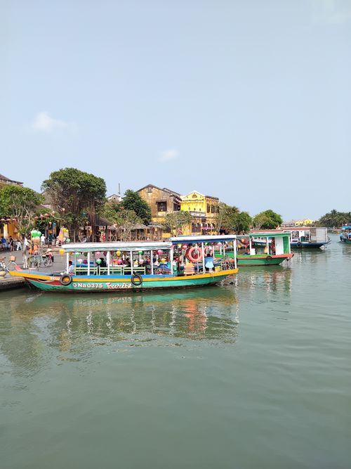 Free Vibrant riverboats with scenic view of Hoi An waterfront, capturing the essence of Vietnam's cultural charm. Stock Photo