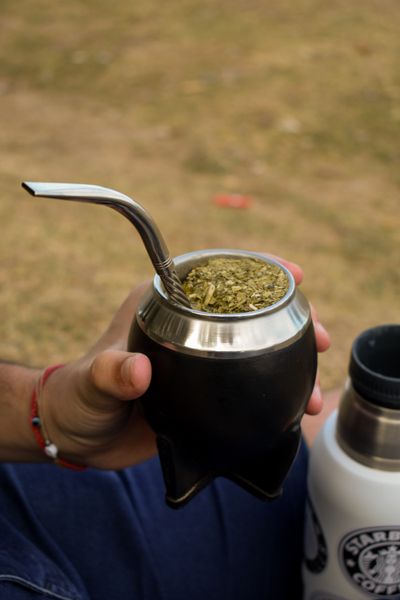 Loose yerba mate and a metal bombilla in a traditional gourd