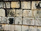 Ancient Mayan stone carvings depicting skulls at the Chichen Itza archaeological site.