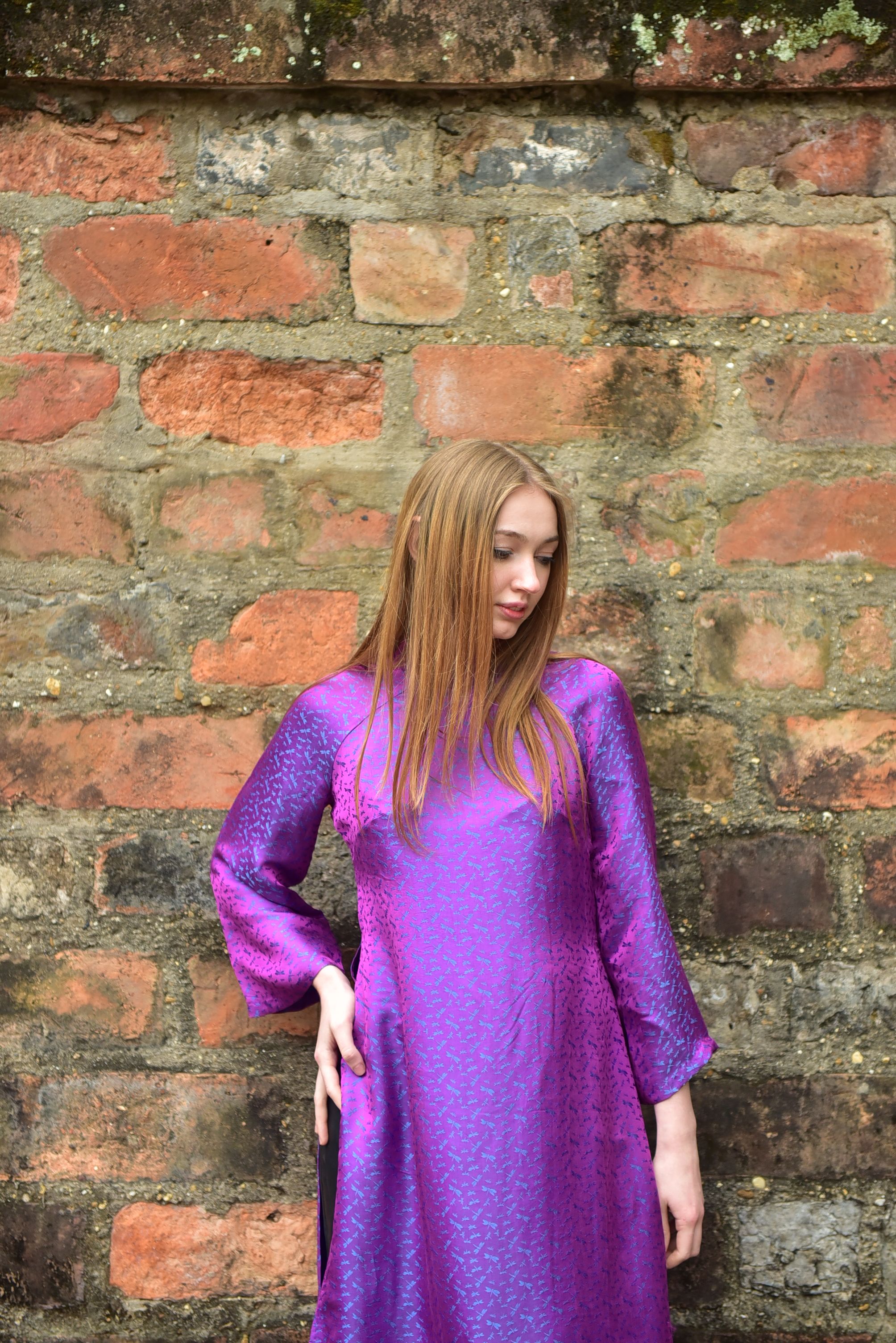 Woman in purple dress against rustic wall free stock photo