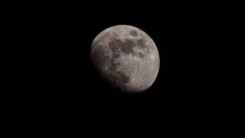 Free A detailed photograph of the half moon against a dark sky, showcasing its craters and textures. Stock Photo